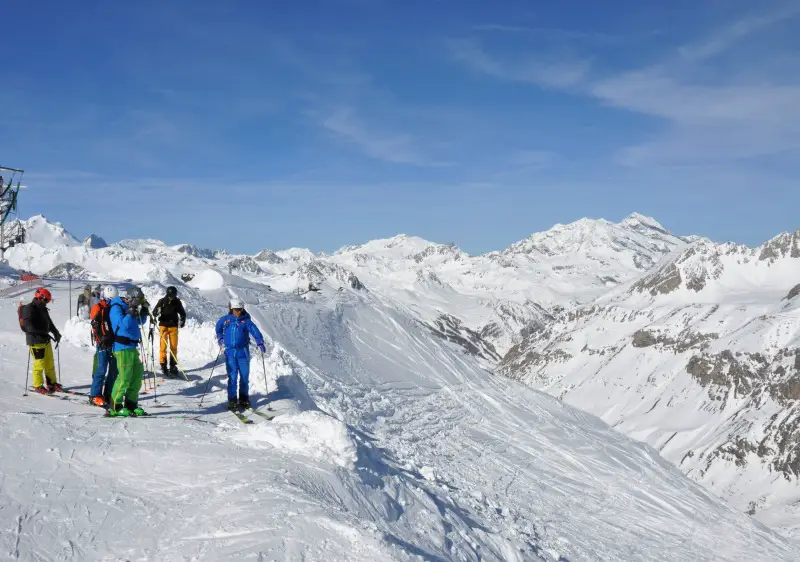 A guided group discuss the freeride descent of the Grand Vallon at the top of Signal lift in Val d